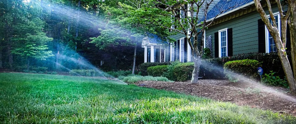 Low view of running sprinklers on a lawn in New Light, NC.